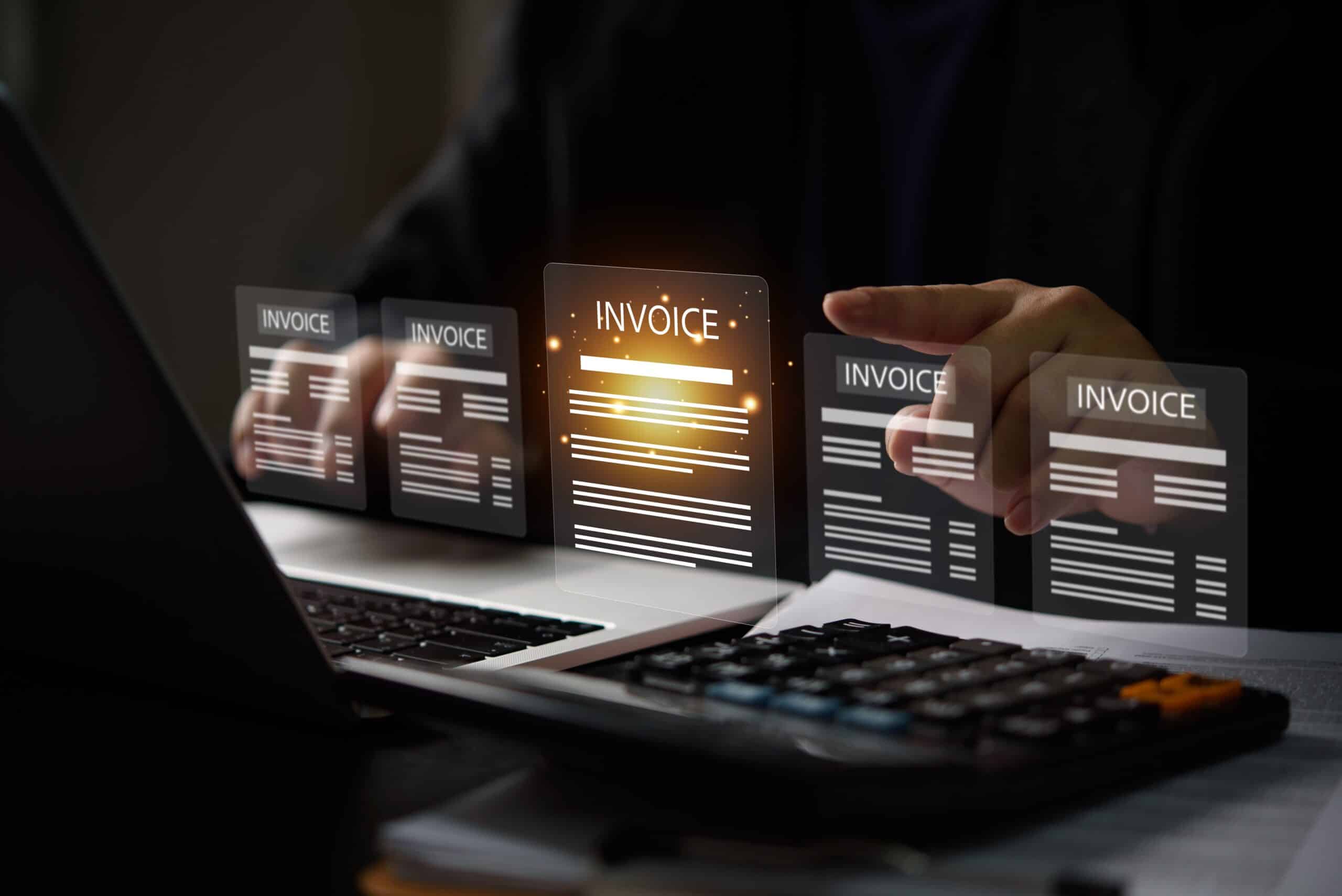 A person interacts with virtual invoice icons above a laptop and calculator. The glowing center invoice emphasizes a digital financial management theme.